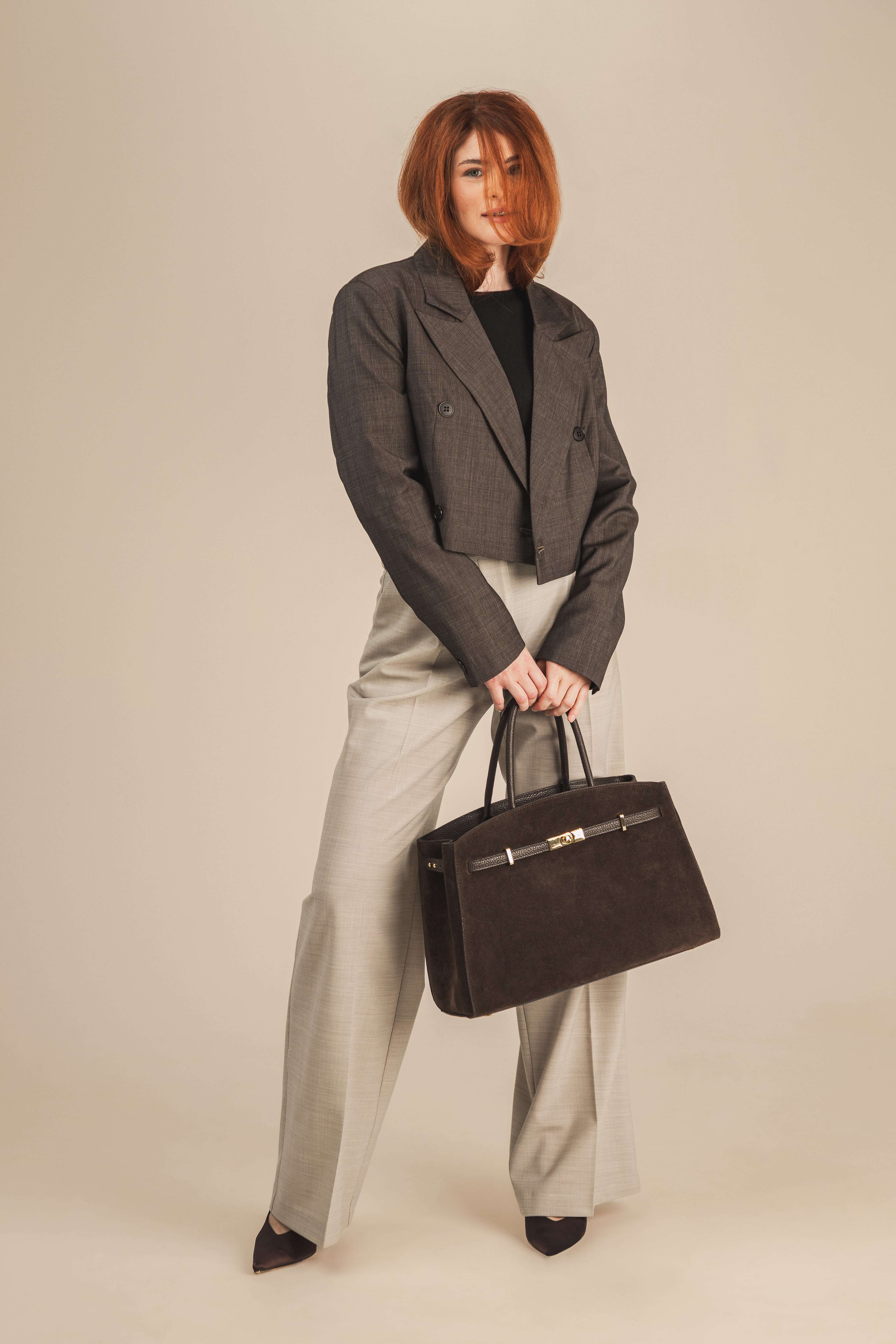 Biznesowy szyk, w którym główną rolę grają perfekcyjnie skrojone, wełniane spodnie w kant, dopełnione elegancką marynarką i pojemną, wyrazistą torbą