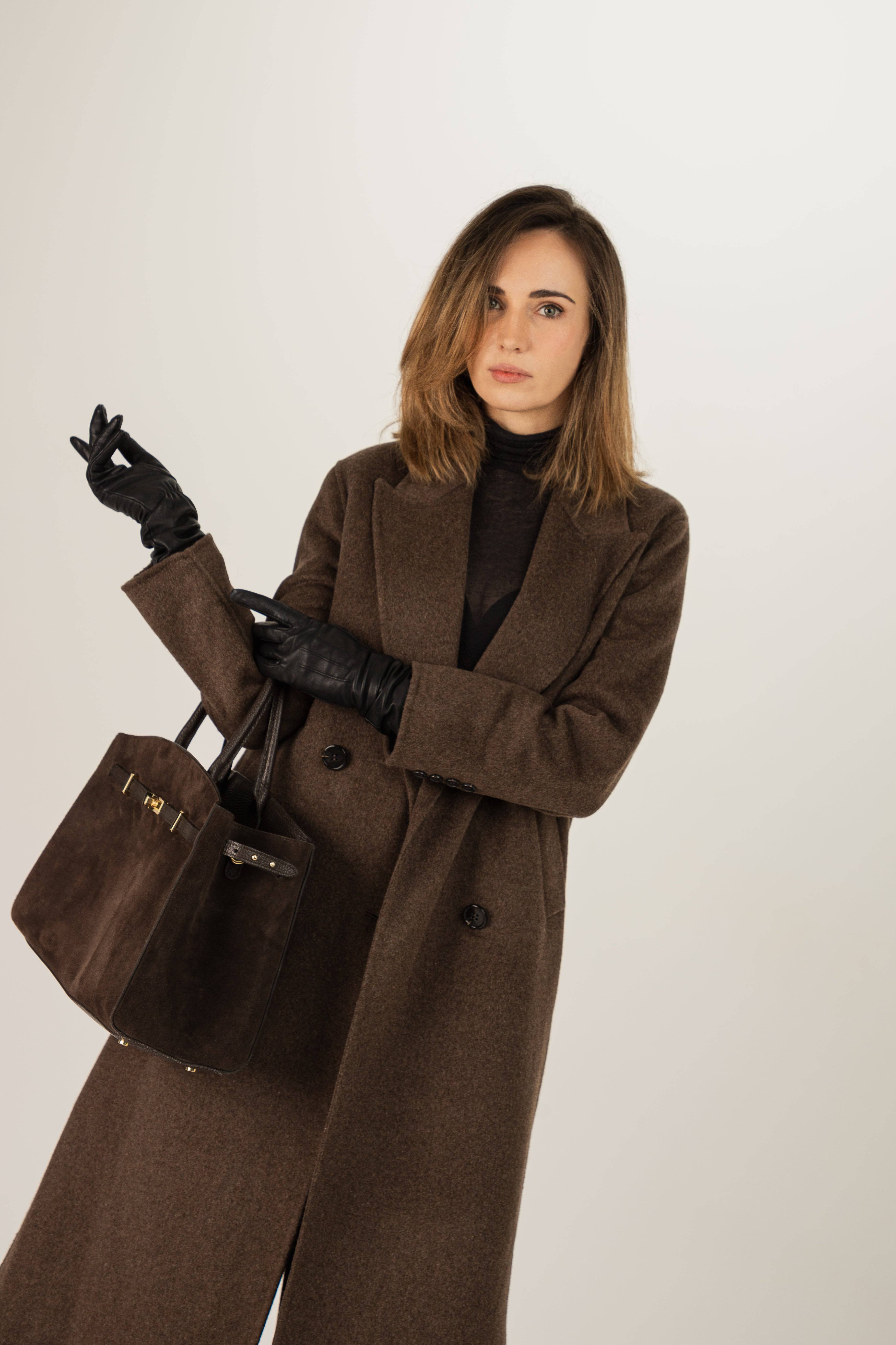 Długi wełniany płaszcz dwurzędowy. W stylizacji wykorzystano czarne spodnie ze skóry oraz dużą, brązową torbę.