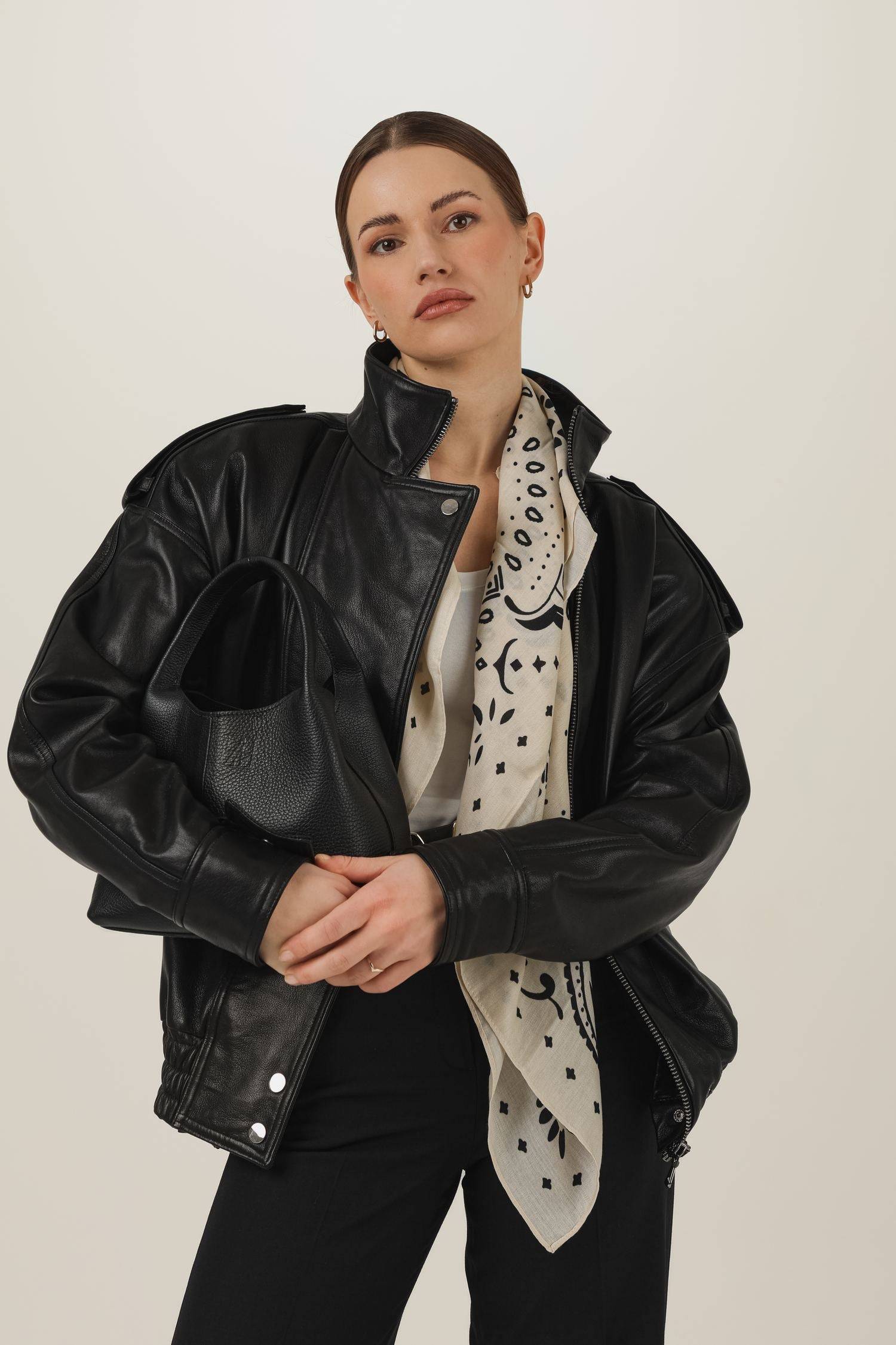 Skórzana kurtka w stylu lat 90. oversize z czarną skórzaną torebką i chustą z wiskozy