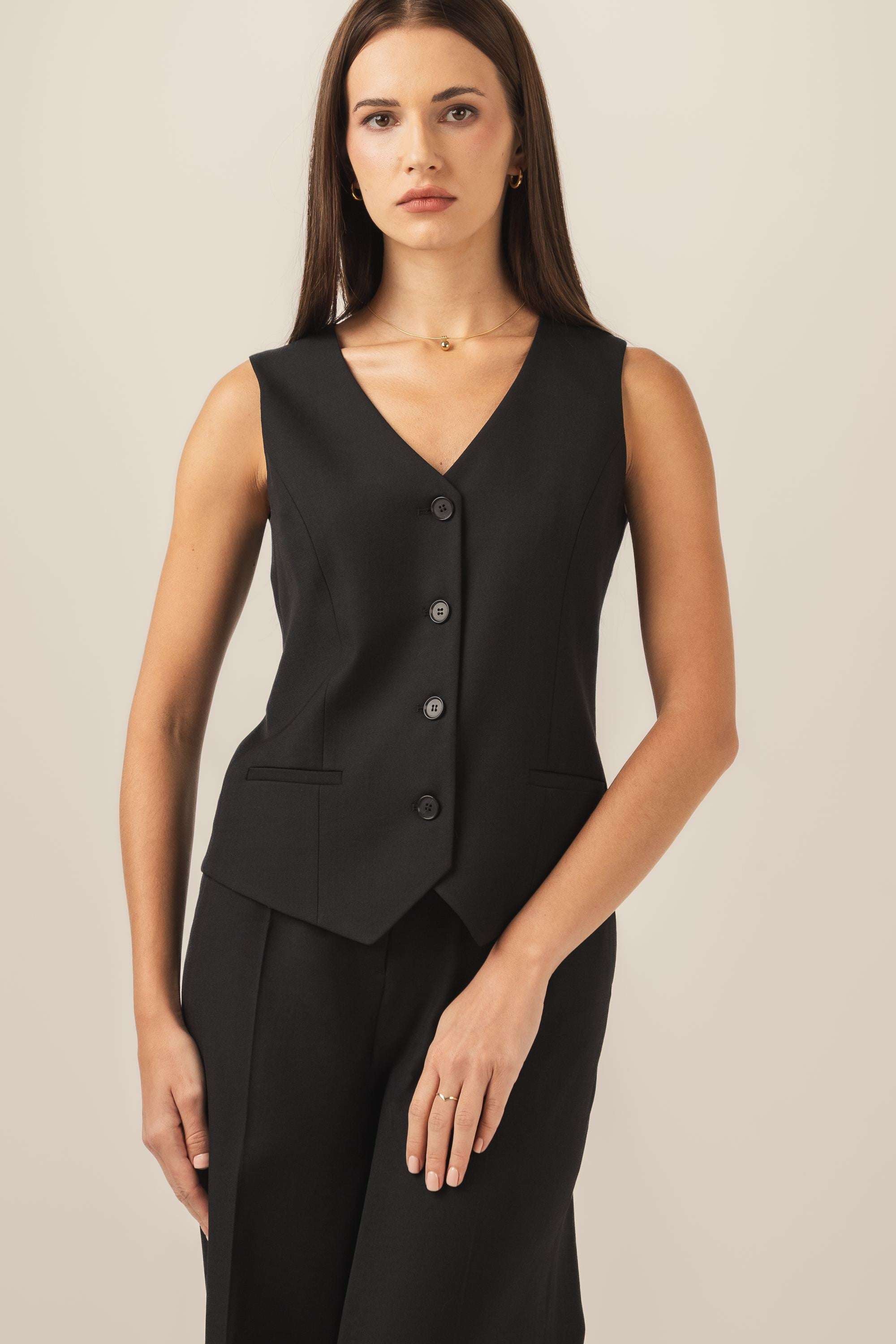Klasyczna czarna kamizelka z modelującymi cięciami podkreślające talię z eleganckimi spodniami z tego samego materiału