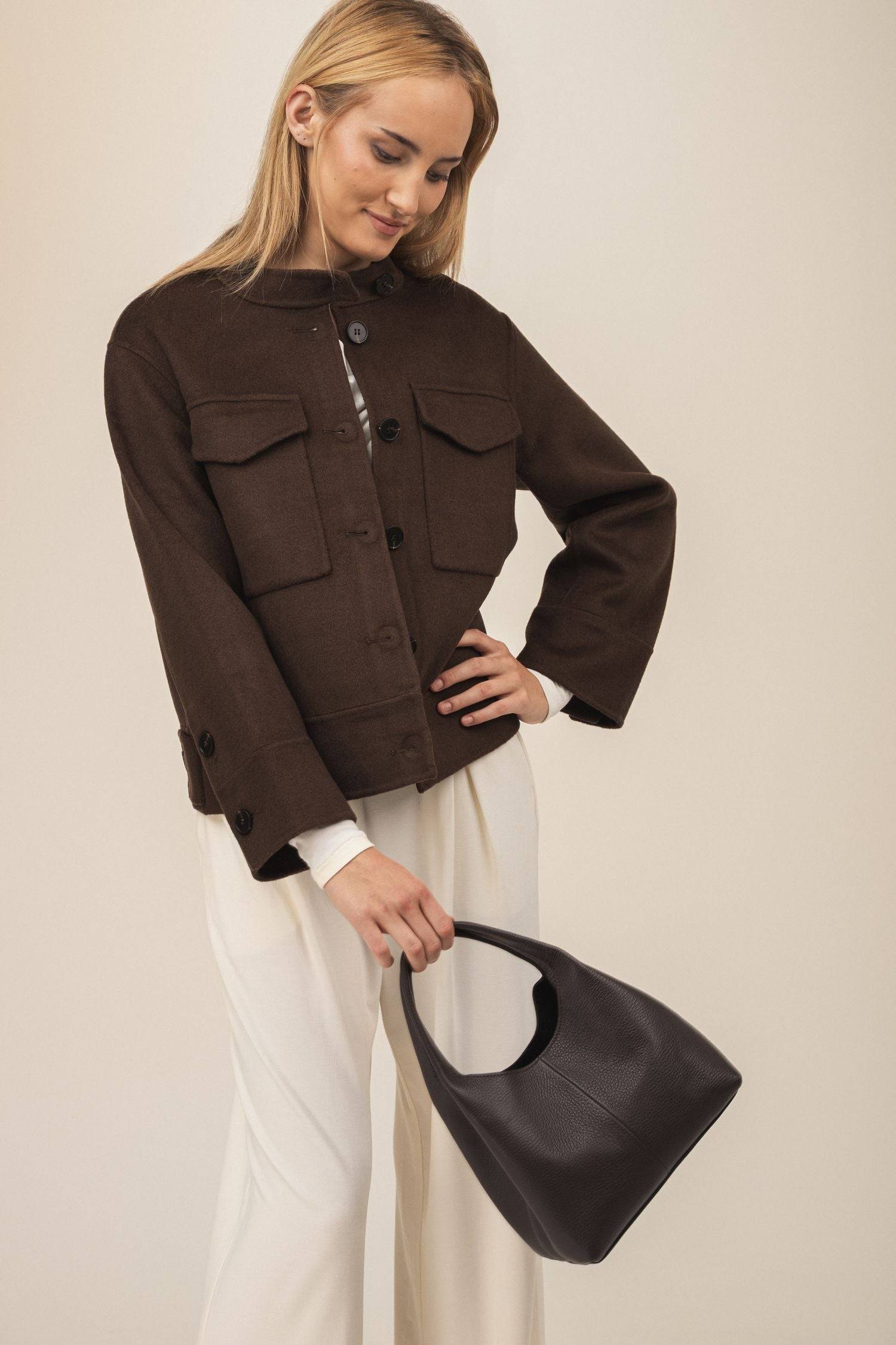 Wełniana damska krótka kurtka - Era w kolorze czekoladowym wystylizowana z jasnym bambusowym kompletem i brązową torebką - zdjęcie wykonane w ruchu