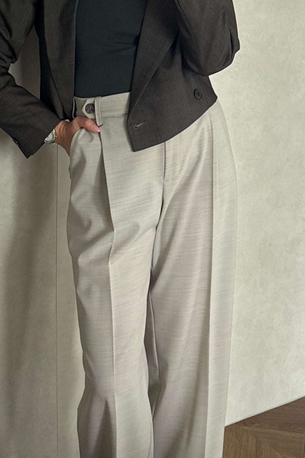 Wełniane spodnie damskie z kantem. Prezentowane w eleganckiej stylizacji z dopasowaną marynarką