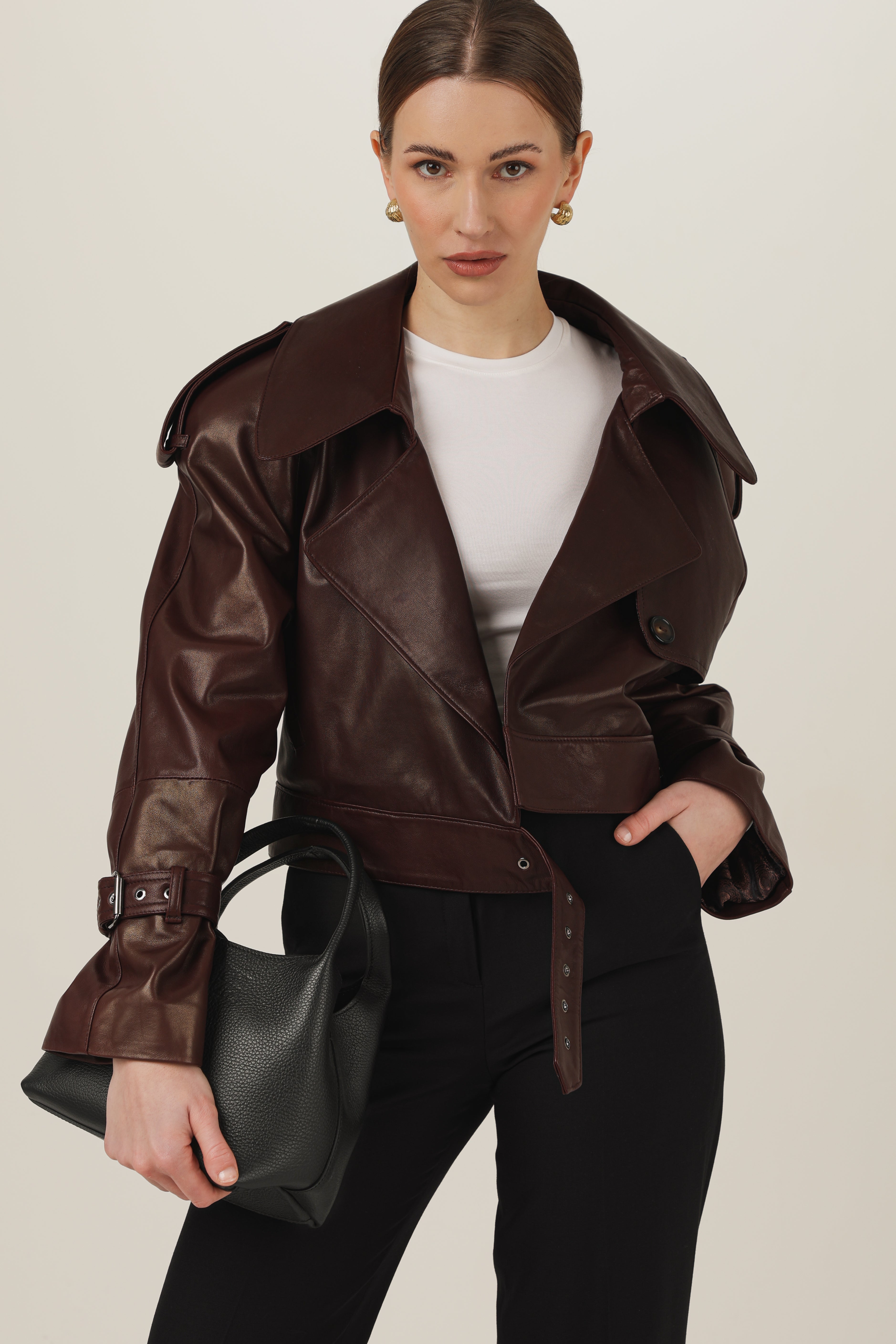Modelka w stylizacji quiet luxury z brązową kurtką skórzaną oversize i paskiem regulującym talię – polska produkcja rzemieślnicza.