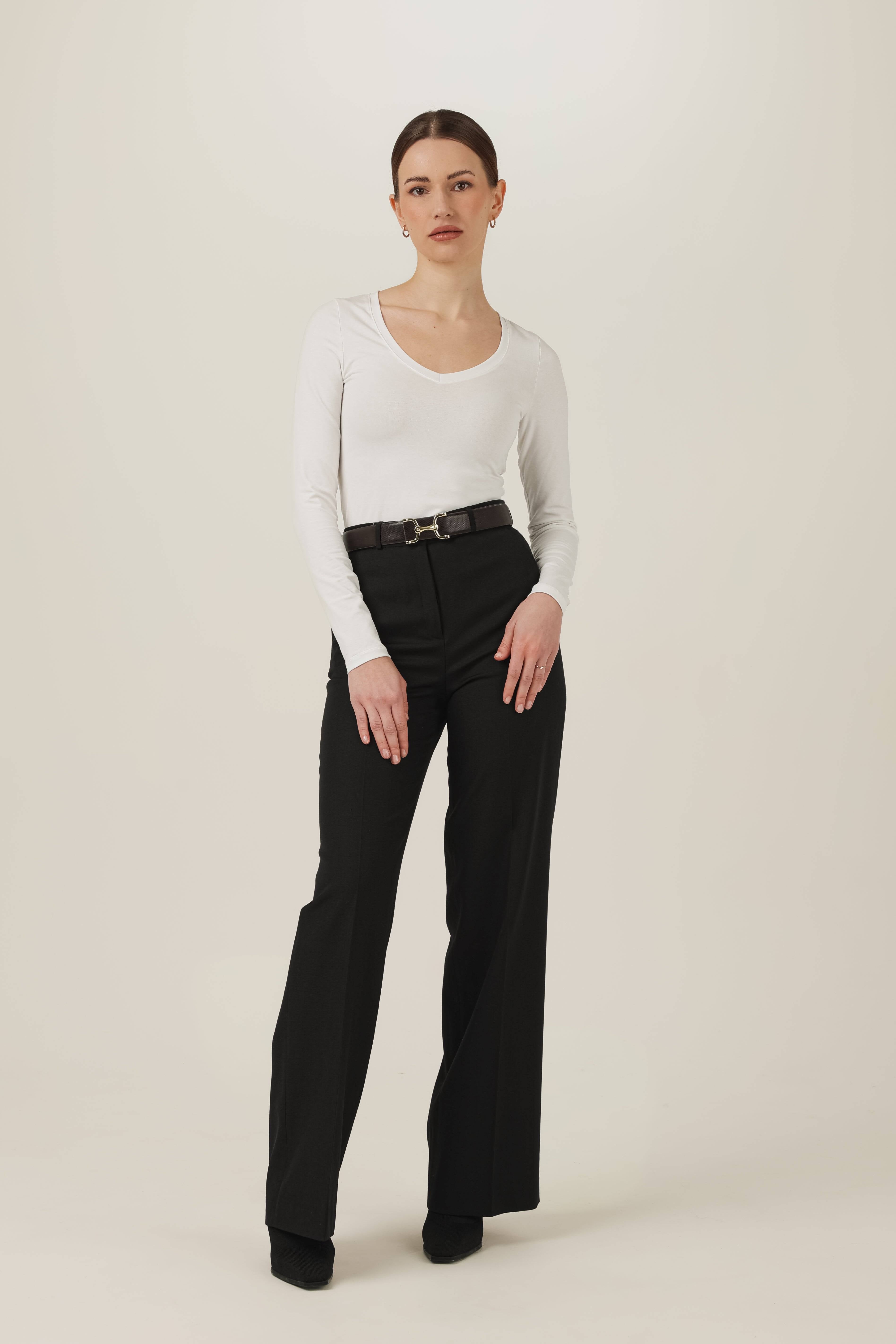 Dopasowany biały top z długim rękawem i dekoltem V z czarnymi spodniami z wysokim stanem - cała stylizacja